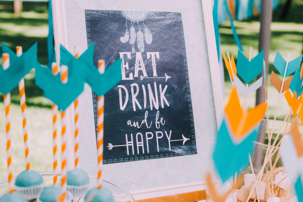 Schild auf einem Buffet mit der Aufschrift "Eat Drink and be happy"